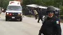 Petugas kepolisian berjaga di lokasi kecelakaan sebuah bus wisata yang terbalik di Quintana Roo, Meksiko, Selasa (19/12). Pihak berwenang belum mengeluarkan data resmi mengenai kewarganegaraan korban tewas. (Manuel Jesús ORTEGA CANCHE/AFP)