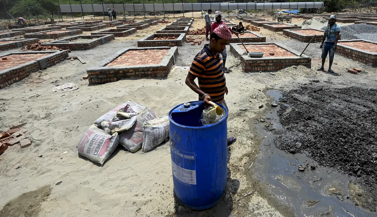 Para buruh bekerja membangun tempat kremasi di ladang kosong di New Delhi, India, Rabu (5/5/2021). Jumlah kasus COVID-19 di India meningkat pesat dibanding awal April lalu ketika masih di kisaran 15 juta. (Money SHARMA/AFP)