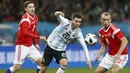 Gelandang Argentina, Giovani Lo Celso, menghindari kejaran pemain Rusia pada laga persahabatan jelang Piala Dunia 2018 di Stadion Luzhniki, Moskow, Sabtu (11/11/2017). Rusia kalah 0-1 dari Argentina. (AP/Pavel Golovkin)