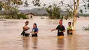 Warga mengarungi jalan raya yang banjir terjangan topan Phanfone di Ormoc City, Provinsi Leyte, Filipina, Rabu (25/12/2019). Topan membuat jutaan warga di negara yang mayoritas beragama Katolik itu merayakan Natal dengan kesedihan. (RONALD FRANK DEJON/AFP)