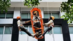 Mahasiswa mengikuti simulasi Vertical Rescue atau evakuasi vertikal selama latihan gempa bumi dan bencana di Universitas Syiah Kuala, Banda Aceh pada Selasa 21 Oktober 2025. (CHAIDEER MAHYUDDIN/AFP)