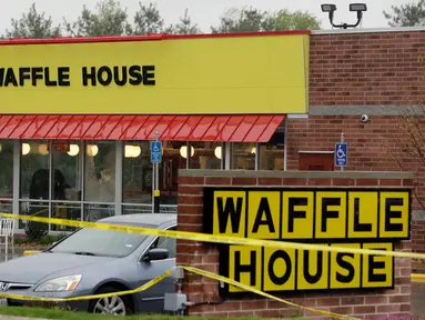 Garis polisi terpasang di lokasi penembakan yang terjadi di  area restoran Waffle House dekat Nashville, Tennessee, Minggu (23/4). Seorang pria telanjang hanya berjaket hijau menembak mati sedikitnya empat orang di kedai tersebut. (AP Photo/Mark Humphrey)