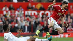 Pemain MU, Ander Herrera (kanan), dijatuhkan pemain Liverpool, Joe Gomez, di Stadion Old Trafford, Inggris. Sabtu (12/9/2015). (EPA/Lindsey Parnaby)