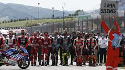 Pebalap MotoGP memberikan penghormatan terakhir dengan mengheningkan cipta selama satu menit bagi pebalap Moto3 Jason Dupasquier sebelum dimulainya balapan MotoGP Italia di Sirkuit Mugello. (Foto: AP Photo/Antonio Calanni)