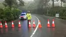 Polisi menutup jalan dan mengalihkan arus lalu lintas usai terjadi longsor di kawasan Puncak Bogor, Jawa Barat (6/2). Menurut pihak kepolisian setempat titik longsor saat ini bertambah dari empat menjadi enam lokasi. (Liputan6.com/Pool/Polres Bogor)