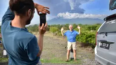 Turis asing foto di depan Gunung Agung yang meletus di Kabupaten Karangasem, Bali, (27/11). Pejabat setempat juga mengimbau agar warga menggunakan masker untuk mengantisipasi adanya debu vulkanik. (AFP/Sonny Tumbelaka)