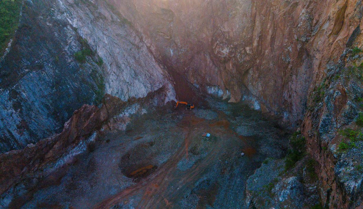 Sebagaimana diketahui, tambang ilegal dapat memicu kerusakan ekosistem lingkungan yang parah, seperti erosi, polusi air, dan lubang tambang yang dibiarkan begitu saja. Tampak foto udara menunjukkan sebuah ekskavator yang bekerja di lokasi penambangan pasir ilegal pada Hari Bumi di Peukan Bada, Aceh, pada Rabu 22 April 2026. (CHAIDEER MAHYUDDIN/AFP)