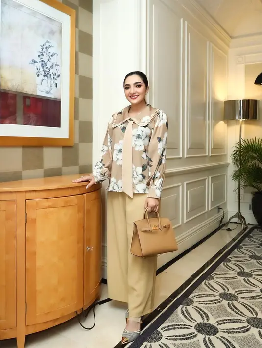 Gaya kasual Ashanty pun menarik untuk dijadikan inspirasi. Di sini, Ashanty mengenakan atasan bermotif floral dengan kerah lebar yang cantik, dipadukan dengan celana kain dan menenteng handbag yang semuanya berwarna cokelat senada. [Foto: Instagram/ashanty_ash]
