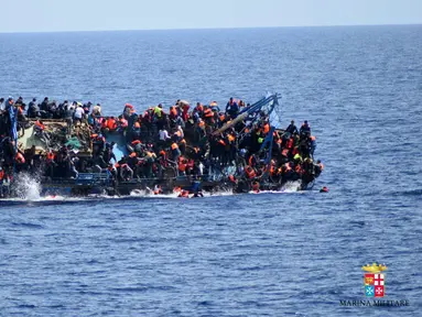 Angkatan Laut (AL) Italia merilis gambar sebuah perahu yang berisi para migran terbalik di lepas pantai Libya, Rabu (25/5). Tujuh orang tewas tenggelam, sementara 500 orang lainnya berhasil diselamatkan dalam insiden tersebut (STR/AFP MARINA MILITARE/AFP)