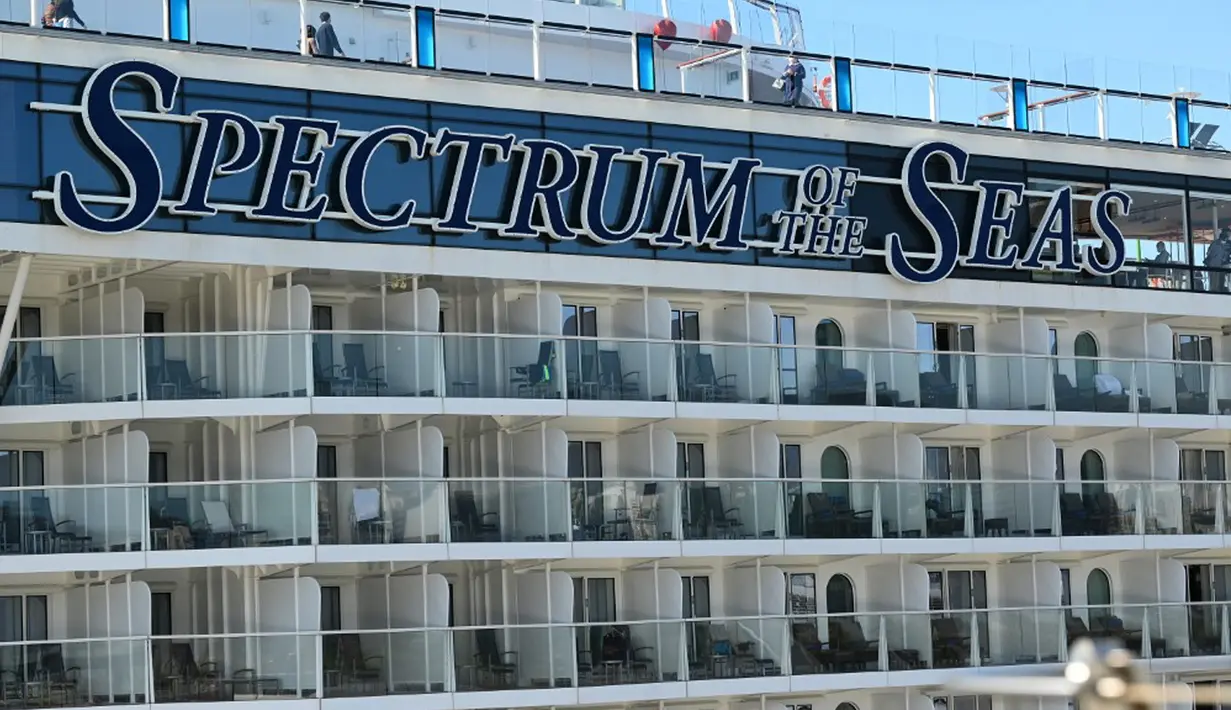Penumpang dan awak terlihat pada kapal pesiar Spectrum of the Seas di Hong Kong, Rabu (5/1/2022). Spectrum of the Seas diperintahkan kembali ke kota untuk pengujian virus corona COVID-19 setelah sembilan orang ditemukan memiliki kontak dekat dengan varian Omicron baru-baru ini. (PETER PARKS/AFP)