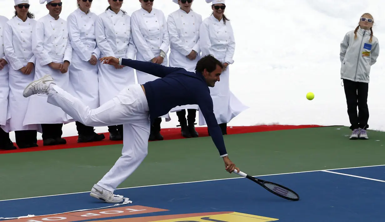 Roger Federer berusaha mengembalikan bola ke pemain ski AS, Lindsey Vonn, saat berlaga di sesi promosi gletser Aletsch, Jungfraujoch, (17/7/2014). (REUTERS/Denis Balibouse)