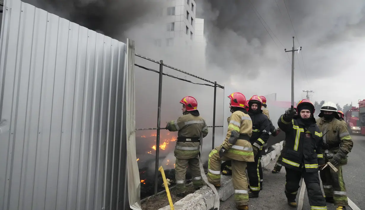 Petugas pemadam kebakaran berusaha memadamkan api di pusat logistik yang rusak setelah penembakan di Kiev, Ukraina, Kamis (3/3/2022). Rusia telah meluncurkan serangan jarak jauh ke Ukraina, menghantam kota dan pangkalan dengan serangan udara atau penembakan. (AP Photo/Efrem Lukatsky)