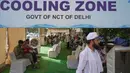 Para pengguna jalan beristirahat di stasiun pendingin pinggir jalan yang didirikan oleh pemerintah untuk memberikan kenyamanan bagi masyarakat dari teriknya musim panas di New Delhi, India, Rabu, 20 Mei 2026. (AP Photo/Manish Swarup)