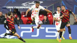 Pemain RB Leipzig Christopher Nkunku (tengah) mengontrol bola udara di depan pemain Manchester City Bernardo Silva (kiri) dan Kyle Walker (kanan) pada pertandingan sepak bola leg pertama babak 16 Liga Champions di Leipzig, Jerman, 22 Februari 2023. Pertandingan berakhir imbang 1-1. (AP Photo/Andreas Gora)