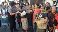 Polwan membagi-bagikan bakul dan kain selendang kepada ibu-ibu buruh gendongan di Solo (Liputan6.com/ Fajar Abrori)