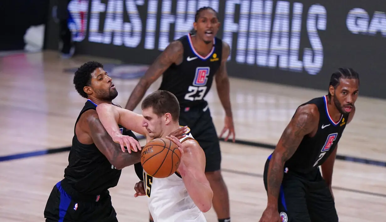 Pebasket Denver Nuggets, Nikola Jokic , berebut bola dengan pebasket Los Angeles Clippers,Paul George, pada gim ketujuh semifinal playoff NBA di Lake Buena Vista, Selasa (15/9/2020).  Nuggets menang dengan skor 104-89. (AP/Mark J. Terrill)