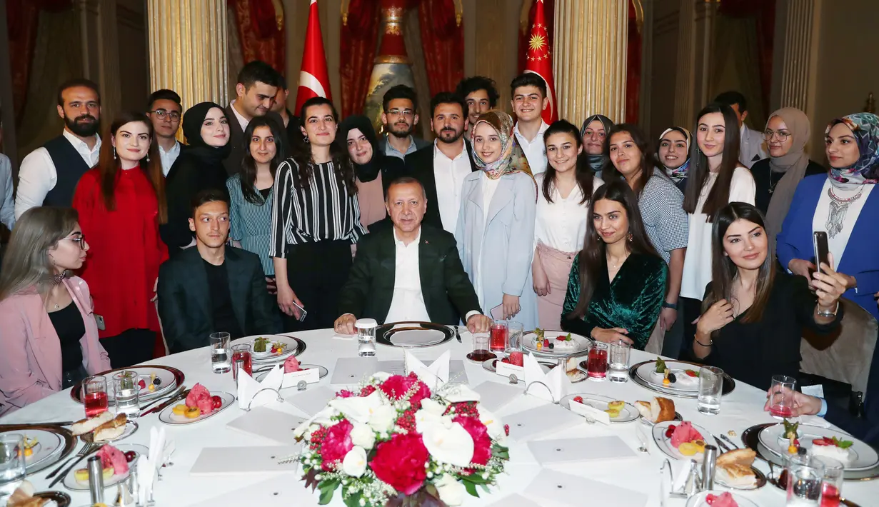 Presiden Turki Recep Tayyip Erdogan foto bersama dengan Gelandang Arsenal, Mesut Ozil dan kekasihnya Amine Gulse usai acara buka bersama di Istana Dolmabahce, Istanbul (19/5). (Stringer/Turkish President's Press Office/AFP)