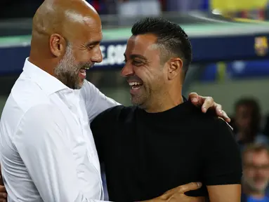 Pelatih Barcelona Xavi Hernandez menyapa manajer Manchester City, Pep Guardiola pada sebuah laga amal di Stadion Camp Nou, Kamis (25/8/2022) dinihari WIB. Laga ini berlangsung menarik karena mempertemukan sang guru dan murid yaitu Pep Guardiola selaku pelatih Man City dan Xavi Hernandes pelatih Barcelona. (AP Photo/Joan Monfort)
