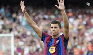 Pemain baru Barcelona yang juga pemain timnas Spanyol, Rodrigo Hernandez "Rodri", memberi isyarat kepada para pendukung saat pertandingan Trofi Joan Gamper ke-61 antara FC Barcelona dan Al Ahly FC di Stadion Camp Nou, Barcelona, ​​pada 19 Agustus 2026. (Lluis GENE/AFP)