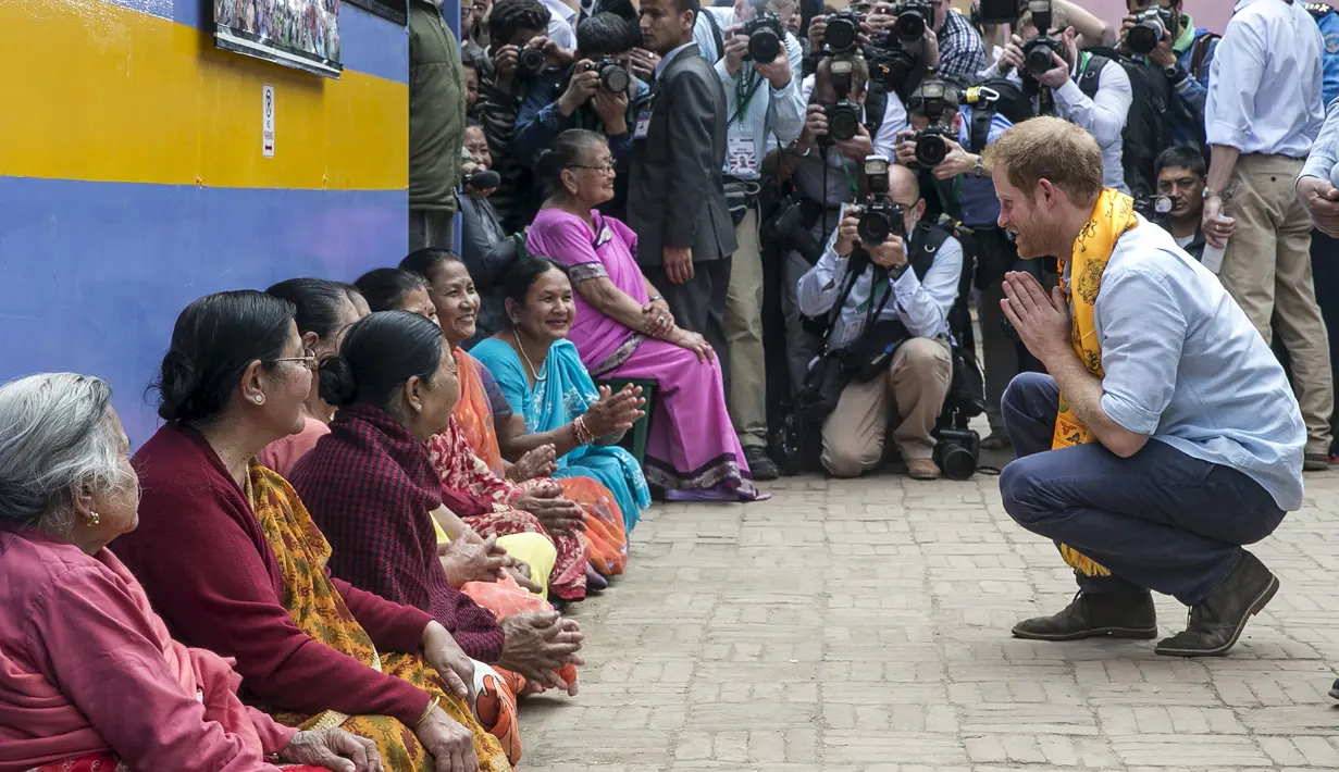 Putra Mahkota Kerajaan Inggris, Pangeran Harry menyapa sejumlah wanita lokal saat mengunjungi situs warisan dunia, Patan Durbar Square di Kathmandu, Nepal, Minggu (20/3). (REUTERS/Prakash Mathema/Pool)