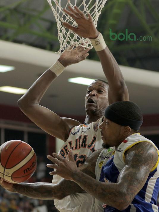 Aksi pemain Satria Muda, Jamarr Johnson melakukan lay up saat diadang pemain Pelita Jaya, Chester Giles pada Final IBL 2018 di GOR Sumantri Brojonegoro, Jakarta, Minggu (22/4/2018). Satria Muda menang 69-64. (Bola.com/Nick Hanoatubun)