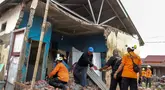 Tim penyelamat membantu warga mencari barang-barang berharga dari reruntuhan rumah mereka yang rusak akibat gempa bumi berkekuatan magnitudo 6,3 di Kelurahan Betungan, Provinsi Bengkulu pada Jumat 23 Mei 2025. (DIVA MARHA/AFP)