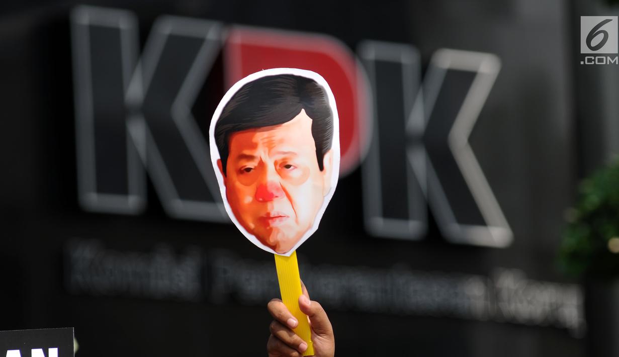 Aktivis Koalisi Masyarakat Sipil Anti Korupsi mengangkat topeng saat aksi teatrikal di depan Gedung KPK, Jakarta, Kamis (14/9). Mereka menuntut KPK menahan tersangka kasus dugaan korupsi KTP elektronik, Setya Novanto. (Liputan6.com/Helmi Fithriansyah)