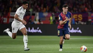 Gelandang Real Madrid asal Inggris #05, Jude Bellingham, menantang gelandang Barcelona asal Spanyol #08, Pedri, dalam pertandingan final Copa del Rey (Piala Raja) antara FC Barcelona dan Real Madrid CF di Stadion La Cartuja, Sevilla, pada 26 April 2025.Josep LAGO / AFP