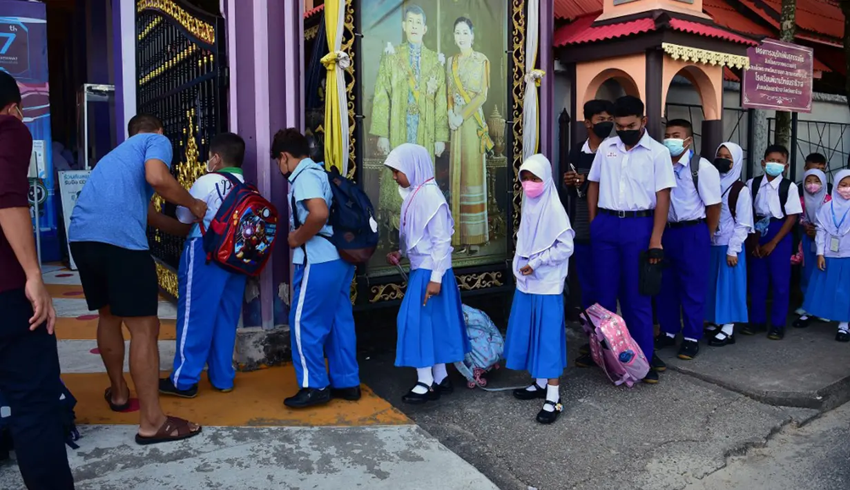 Para siswa tiba di Sekolah Pimarnvit, Provinsi Narathiwat, Thailand, 20 Mei 2022. Thailand melanjutkan sekolah tatap muka secara nasional untuk tahun ajaran baru setelah bertahun-tahun terganggu karena pandemi COVID-19. (Madaree TOHLALA/AFP)