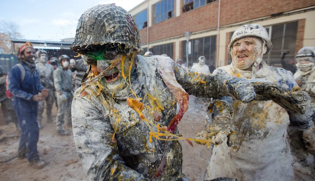 Orang-orang yang mengenakan pakaian militer tiruan ikut serta dalam perang makanan "Els Enfarinats" di Kota Ibi, Spanyol, 28 Desember 2022. (JAIME REINA/AFP)