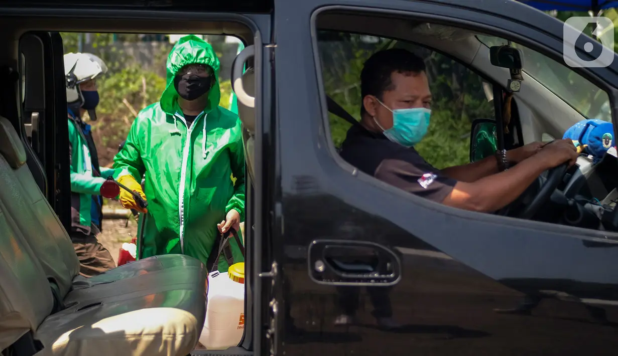 Petugas menyemprotkan cairan disinfektan pada kendaraan di Posko Aman Bersama Gojek, Kemayoran, Jakarta, Kamis (23/4/2020). Sebanyak 130 titik posko telah dioperasikan di 16 kota untuk memastikan mitra Gojek dapat bertugas dengan aman selama pandemi Covid-19. (Liputan6.com/HO/Ading)