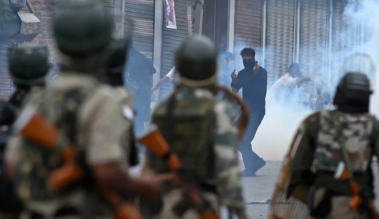 Pemuda Kashmir saat bentrok dengan pasukan pemerintah India di pusat kota Srinagar (2/9). Bentrokan pecah setelah salat Idul Adha. Dimana pasukan polisi dan paramiliter menembaki para pemerotes di dekat tempat salat. (AFP Photo/Tauseef Mustafa)