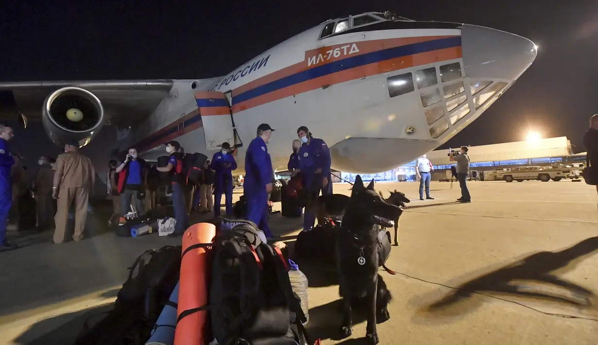 Pegawai Darurat Rusia menunggu dekat pesawat kargo setibanya mereka di sebuah bandara di Beirut, Lebanon, Rabu (5/8/2020). Rusia mengirim lima paket bantuan ke Lebanon setelah ledakan besar di Pelabuhan Beirut. (AP Photo/Ministry of Emergency Situations press service via AP)