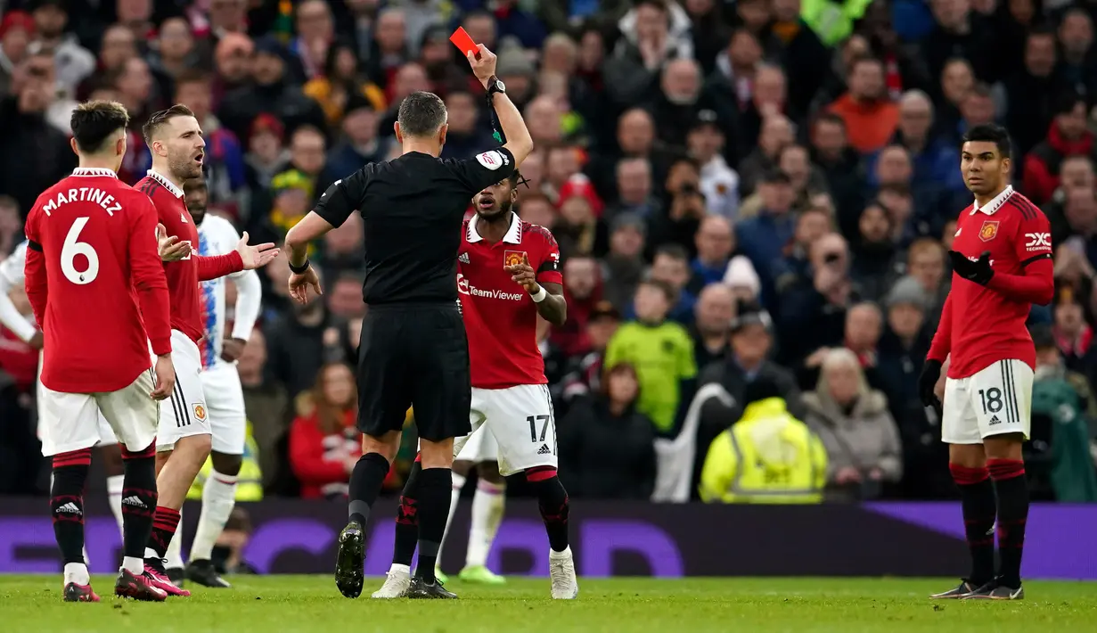 Wasit Andre Marriner memberikan kartu merah kepada pemain Manchester United Casemiro (kanan) saat melawan Crystal Palace pada pertandingan sepak bola Liga Inggris di Stadion Old Trafford, Manchester, Inggris, 4 Februari 2023. Manchester United mengalahkan Crystal Palace dengan skor 2-1. (AP Photo/Dave Thompson)