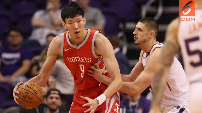 Pebasket Houston Rockets, Zhou Qi, berusaha melewati pebasket Phoenix Suns pada laga NBA di Arizona, AS, Minggu (16/11/2017). (AFP/Christian Petersen)
