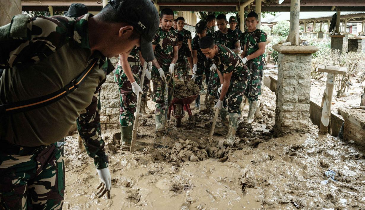 Personel Tentara Nasional Indonesia (TNI) dari YONIF TP 853/BRB, Aceh Timur, membersihkan lumpur di Rumah Sakit Daerah di Aceh Tamiang, pada Selasa 16 Desember 2025, setelah banjir bandang sekitar tiga minggu lalu. Lumpur tebal di banyak lorong dan genangan air dampak banjir bandang yang masih menutup sebagian besar dari Rumah Sakit Daerah Aceh Tamiang. (Yasuyoshi Chiba/AFP)