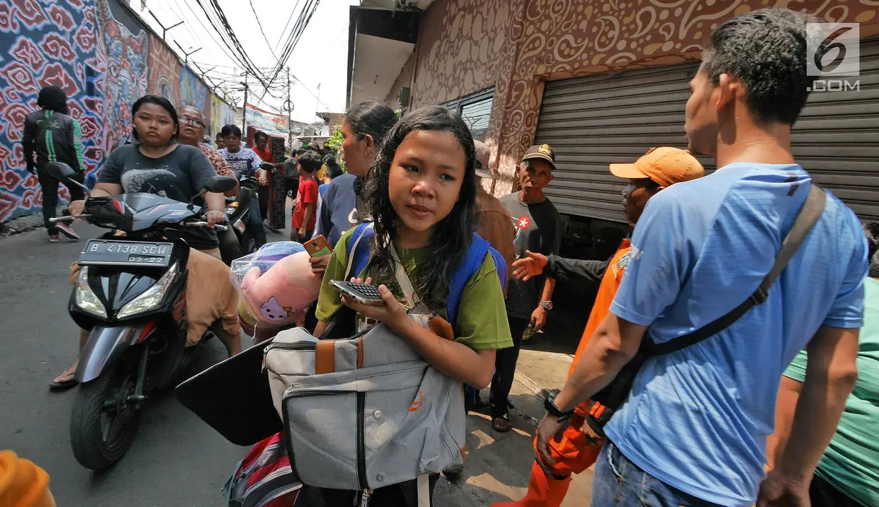 Warga berusaha menyelamatkan harta benda mereka ketika kebakaran melanda permukiman padat penduduk di Manggarai, Jakarta, Rabu (10/7/2019). Belum diketahui pasti penyebab api membakar pemukiman warga tersebut. (Liputan6.com/Herman Zakharia)