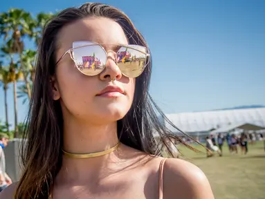 Olivia Guerrieri berpose menggunakan kaca mata saat menghadiri Coachella Music & Arts Festival di Empire Polo Club di Indio, California (15/4). Festival Coachella ini sudah ada sejak 1999. (Photo by Amy Harris/Invision/AP)