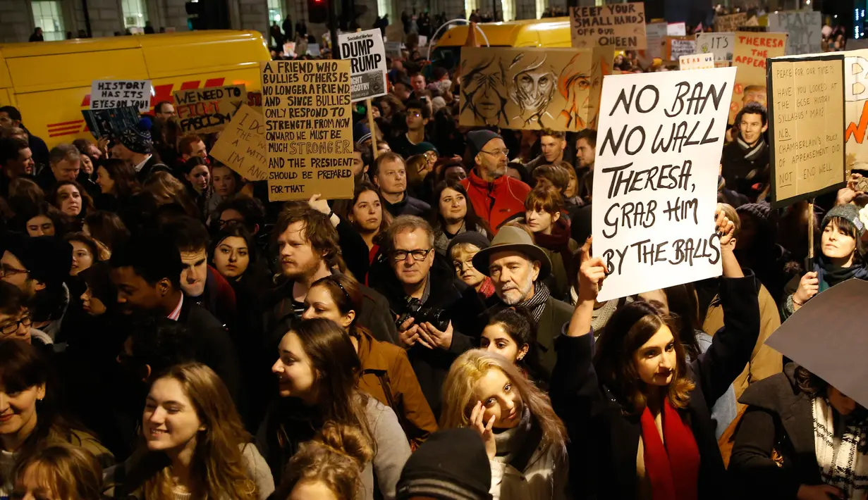 Sejumlah orang turun ke jalan, bergabung dalam aksi unjuk rasa di luar Downing Street, London, Senin (30/1). Mereka memprotes kebijakan Presiden AS Donald Trump yang melarang Muslim dari sejumlah negara memasuki Amerika Serikat. (AP Photo/Alastair Grant)