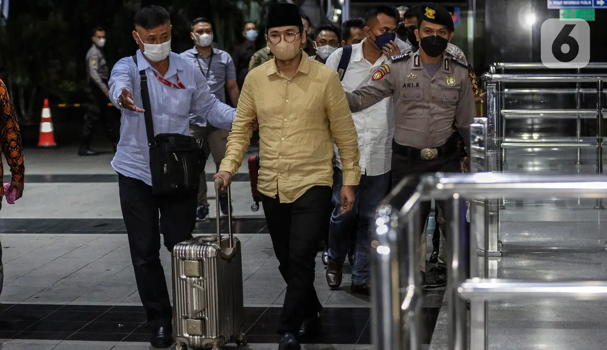 Bupati Bangkalan Abdul Latif Amin Imron membawa koper dan dikawal saat tiba di Gedung Komisi Pemberantasan Korupsi (KPK), Jakarta, Rabu (7/12/2022). KPK menangkap Bupati Bangkalan Abdul Latif Amin Imron sebagai tersangka kasus suap lelang jabatan di Pemerintahan Kabupaten Bangkalan, Jawa Timur. Total kekayaan yang dimiliki Abdul Latif sebanyak Rp 9,9 miliar. (Liputan6.com/Johan Tallo)