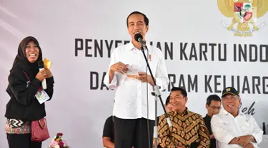 Presiden Joko Widodo atau Jokowi memberi pertanyaan kepada seorang wanita saat penyerahan KIP dan PKH di SMA Negeri 1 Palembang, Sumatra Selatan (22/1). (Liputan6.com/Pool/Biro Setpres)