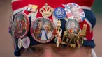 John Loughrey mengenakan topi yang dihiasi dengan memorabilia kerajaan sambil berdiri di sepanjang rute Penobatan Raja di The Mall di London, Selasa, 2 Mei 2023. (AP Photo/Vadim Ghirda)