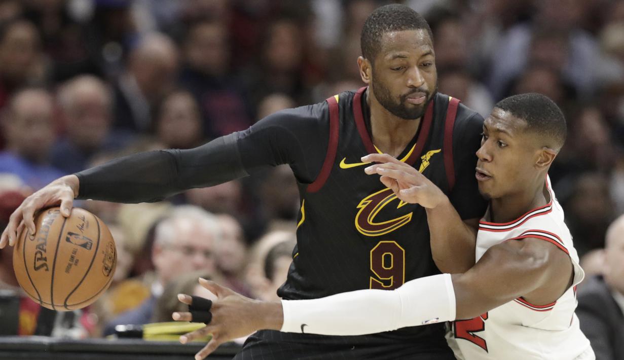 Pemain Cleveland Cavaliers, Dwyane Wade (kiri) berusaha menerobos pertahanan pemain Chicago Bulls, Kris Dunn pada laga NBA basketball game di Quicken Loans Arena, Cleveland, (21/12/2017). Cleveland menang 115-112. (AP/Tony Dejak)