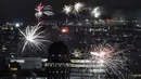 Kembang api menerangi langit di atas Zurich dengan pemandangan Danau Zurich, Swiss, saat perayaan Malam Tahun Baru pada Senin (1/1/2024) dini hari. (Ennio Leanza/Keystone via AP)