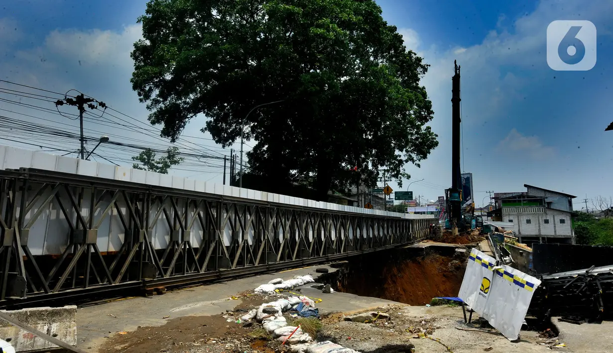 Kondisi jalan amblas di Jembatan Cikereteg Bogor-Sukabumi, Bogor, Jawa Barat, Senin (13/3/2023). Sejak longsor yang terjadi pada Senin (27/2/2023), masyarakat harus mencari jalur alternatif atau berjalan kaki melewati jembatan dan menyambung angkot yang menunggu di seberang. (merdeka.com/Arie Basuki)