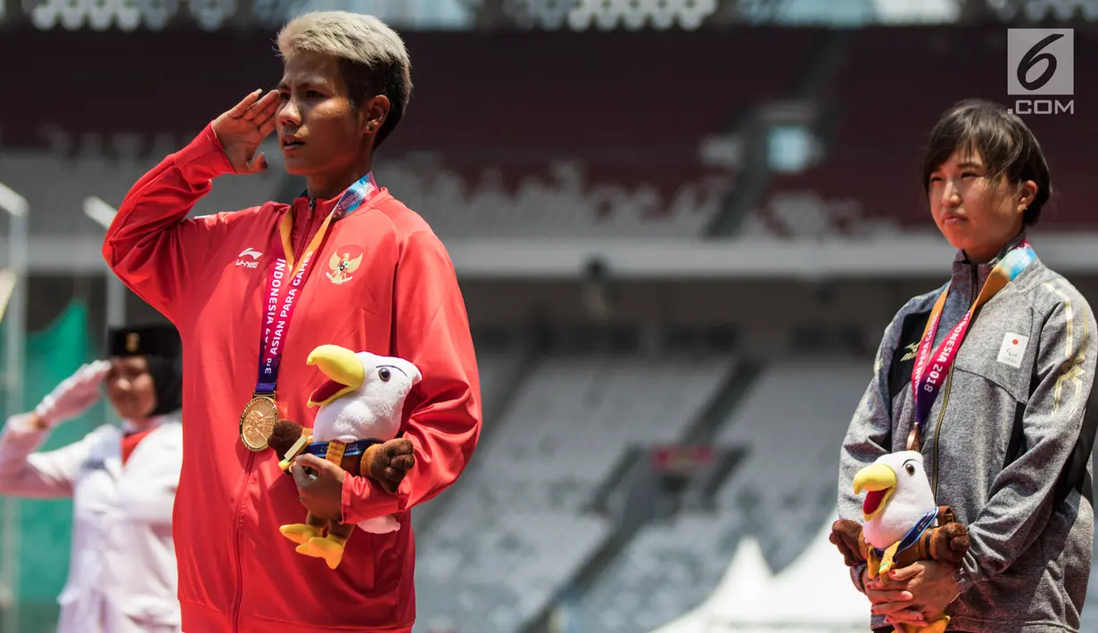 Atlet lompat jauh Indonesia, Rica Oktavia, hormat bendera saat seremoni usai meraih medali emas Asian Para Games 2018 di SUGBK, Jakarta, Senin (8/10). Rica menorehkan lompatan mencapai 5,25 meter. (Bola.com/Vitalis Yogi Trisna)