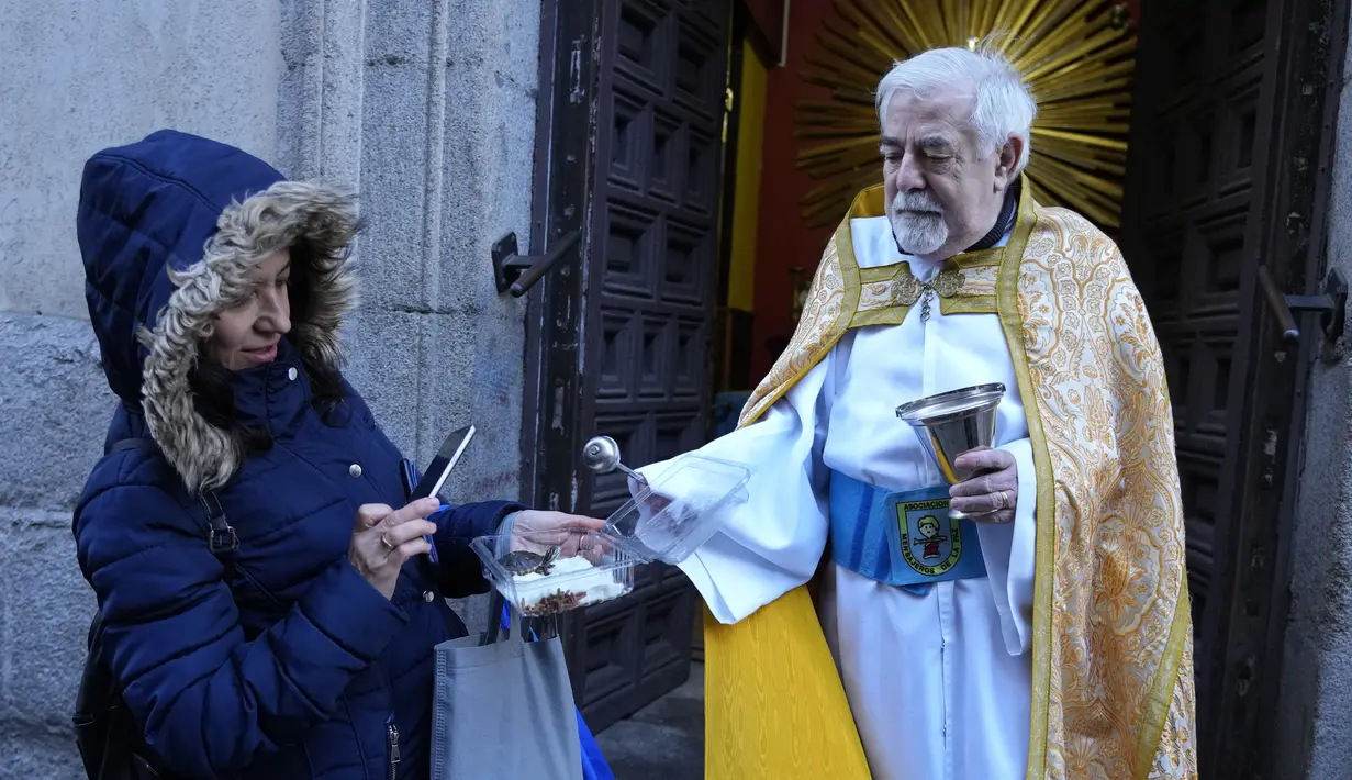 Seorang pendeta memercikkan air suci pada kura-kura di gereja San Anton selama pesta Santo Antonius, santo pelindung hewan, di Madrid, Spanyol, Selasa (17/1/2023). Pesta itu dirayakan setiap tahun di banyak bagian Spanyol dan orang-orang membawa hewan mereka ke gereja untuk diberkati. (AP Photo/Paul White)