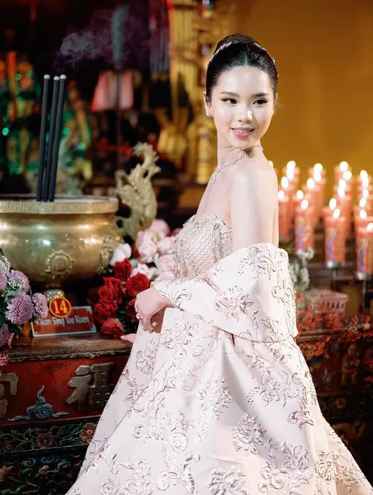 Gwen melengkapi penampilannya dengan perhiasan. Serta makeup natural dengan lipstik pink glossy, dan rambut bergaya sanggul modern dihiasi hairclip [@nancywarrencouture]