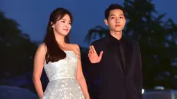 Song Joong Ki dan Song Hye Kyo melambaikan tangan ketika berpose di karpet merah The 52nd Baeksang Art Awards di Seoul, 3 Juni 2016. Song Song Couple dipertemukan sebagai lawan main dalam drama Korea, Descendants of The Sun. (JUNG YEON-JE/AFP)