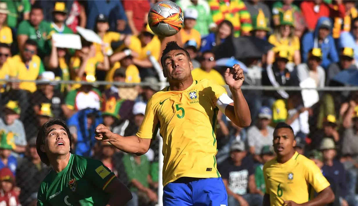 Pemain Brasil, Casemiro menyundul bola melewati adangan pemain Bolivia, Marcelo Martins (kiri)  pada kualifikasi Piala Dunia 2018 zona CONMEBOL di La Paz, Bolivia, (5/10/2017). Brasil bermain imbang 0-0. (AFP/Nelson Almeida)